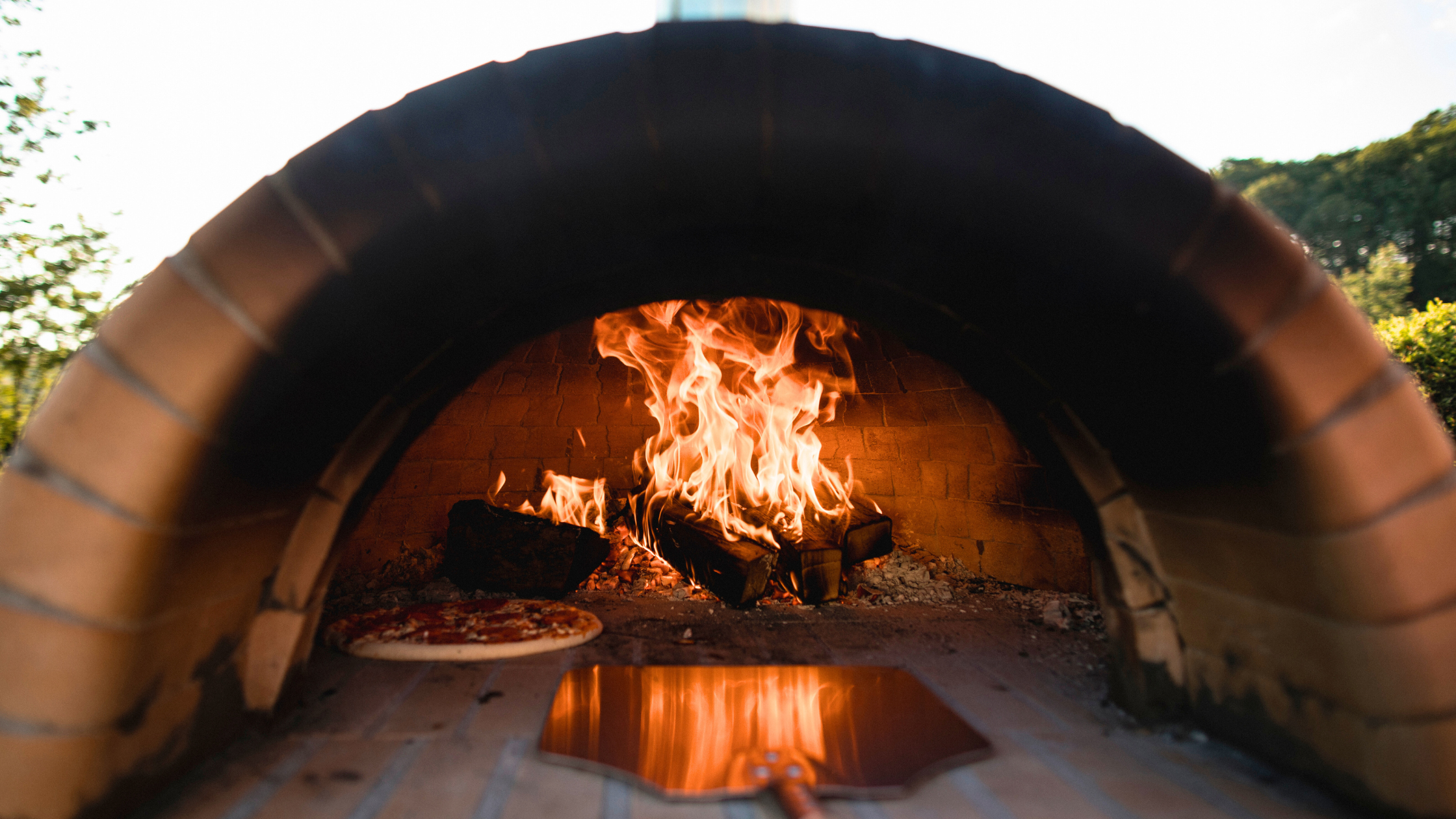 Pizza cooking in an outdoor pizza oven